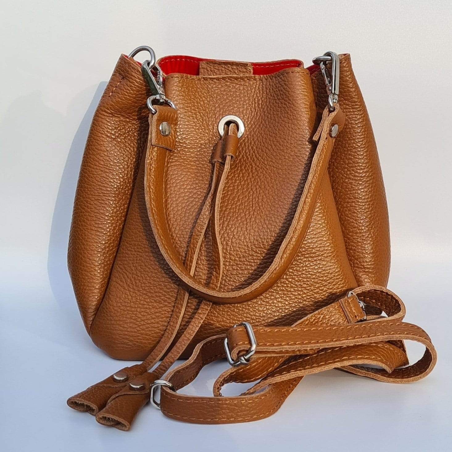 Small bucket bag in tan leather with a handle and a shoulder strap