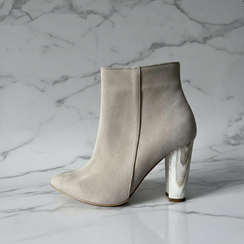 Beige suede ankle boot with a block heel on a grey background