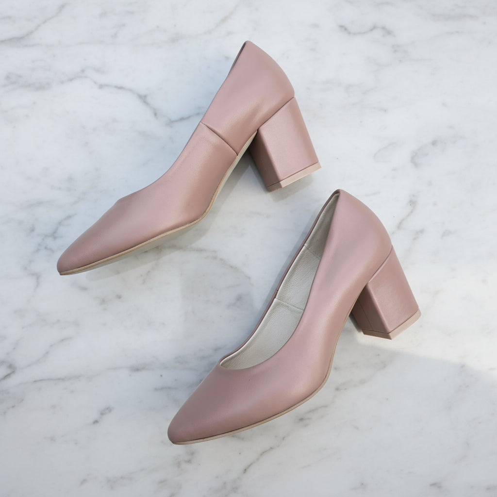 Pair of mauve high-heeled shoes on a light gray surface