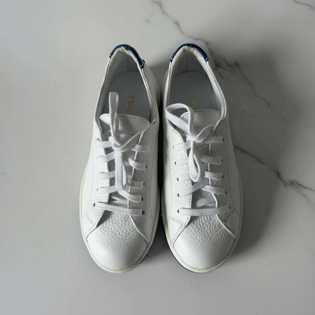 Pair of white sneakers on a gray background