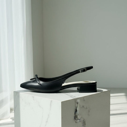 Black slingback shoes on a marble surface