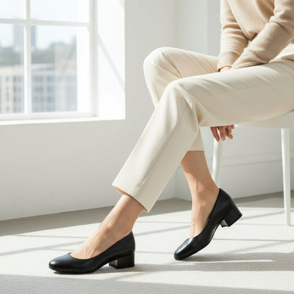Model wearing smart cream tailoring and contrasting black leather pumps.