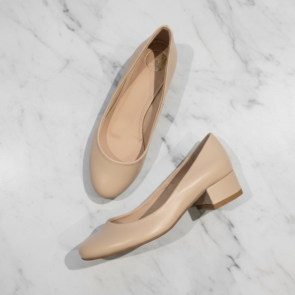 Beige shoes with a block heel on a textured surface