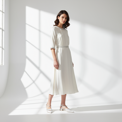 Pair of silver and gold pointed-toe shoes on a marble surface.