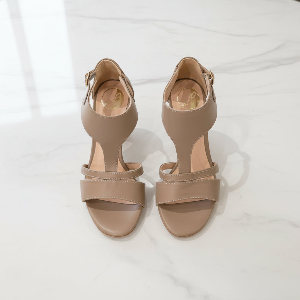 Pair of beige high-heeled sandals on a white background