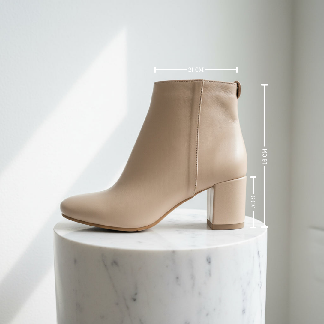 Beige ankle boot on a marble pedestal with measurements indicated
