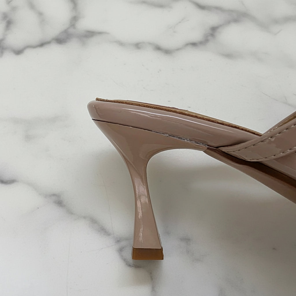 Beige high-heeled shoe on a light gray background