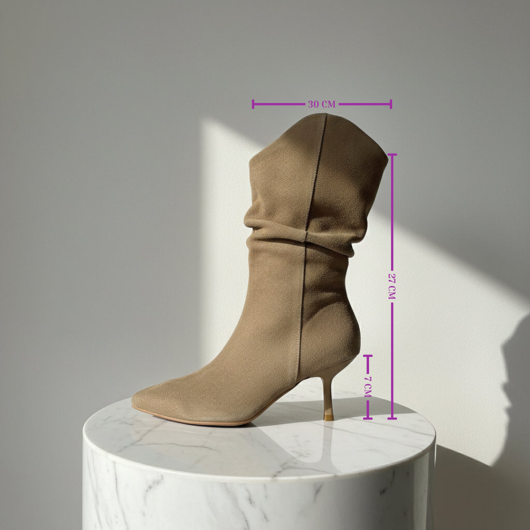 Beige high-heeled boot on a marble pedestal with measurements indicated.