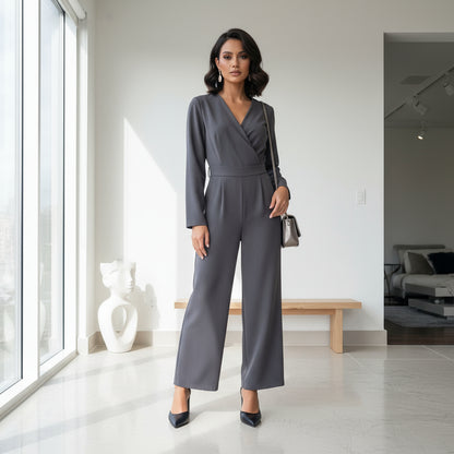 Woman in a gray jumpsuit standing in a modern interior setting