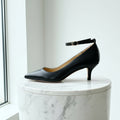 Beige high-heeled shoe on a marble surface with a light background