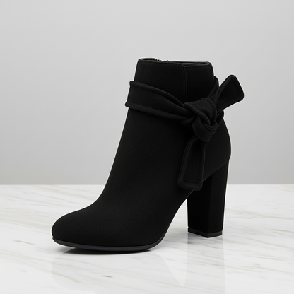Black ankle boot with a bow on a white background