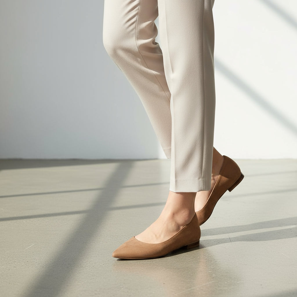 Pair of brown pointed flats on a marble surface