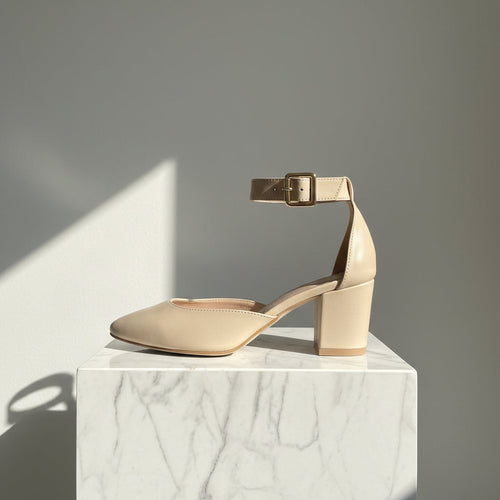 A beige faux-leather block-heel pump with an ankle strap and gold buckle, shown from a side profile on a light gray background.