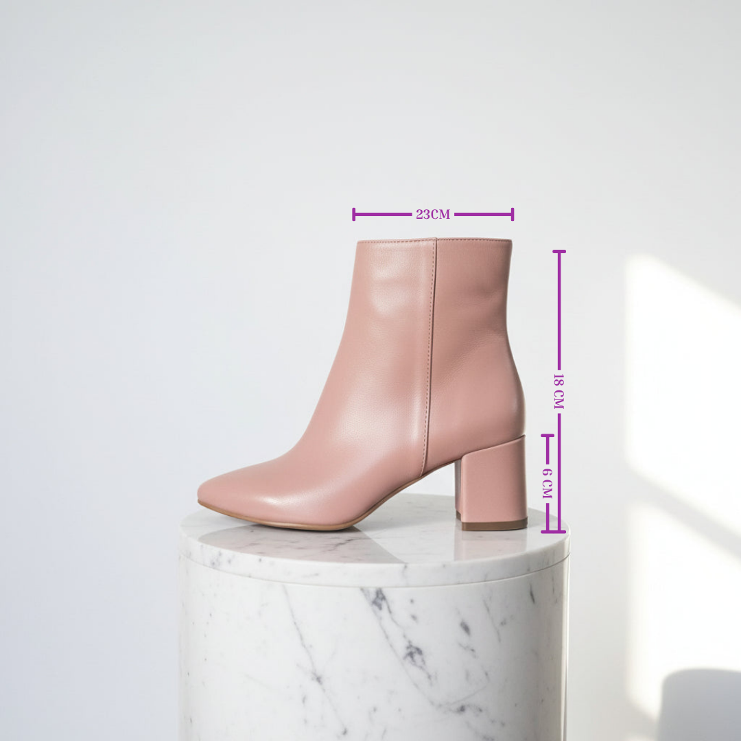 Blush pink leather boots elevated on a marble stand with measurements 