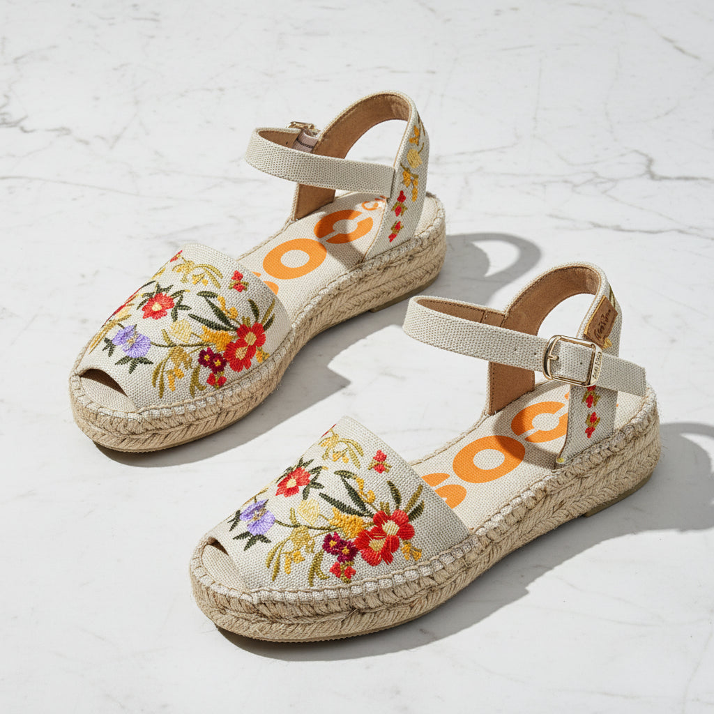 Pair of floral embroidered sandals on a light background