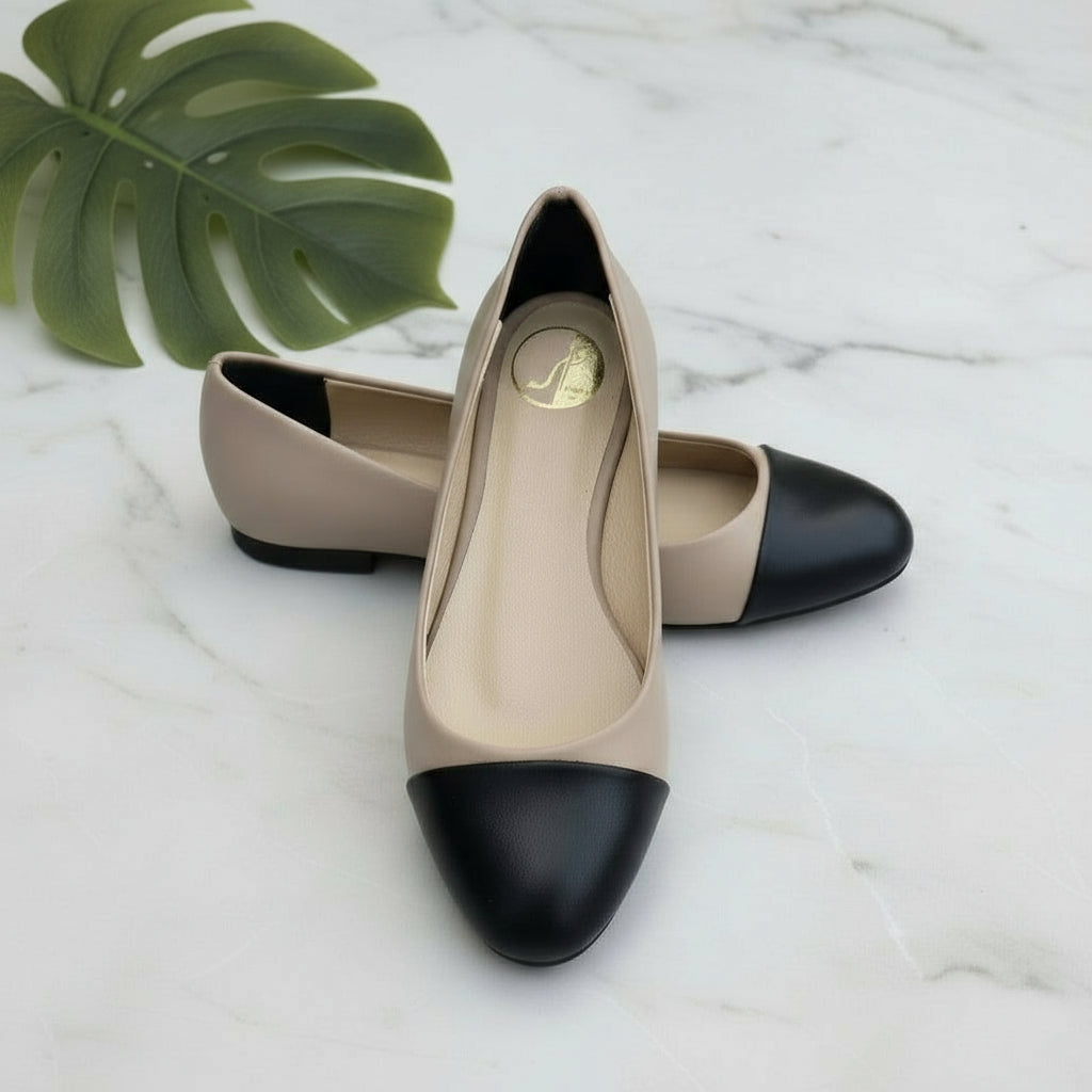 Pair of beige and black shoes on a blue surface