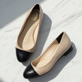Pair of beige and black shoes on a gray background