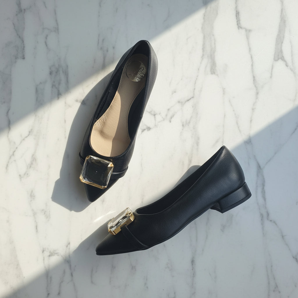 Black shoes with gold buckles on a marble surface