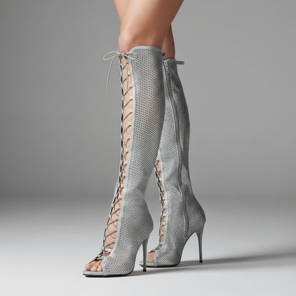 Silver mesh knee-high boots with high heels on a gray background