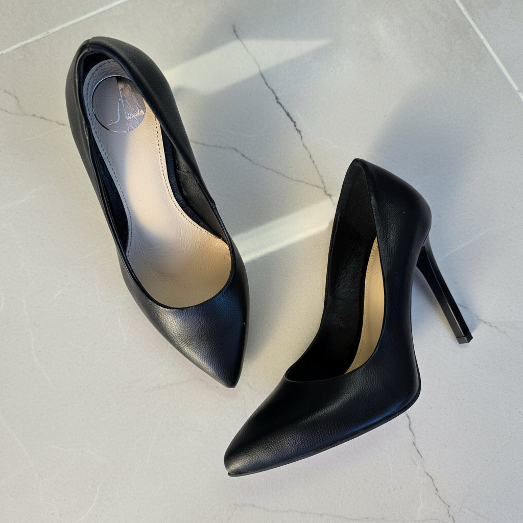Pair of black high-heeled shoes on a light gray surface