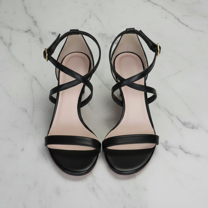 Black strappy sandals on a marble background