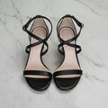 Black strappy sandals on a marble background