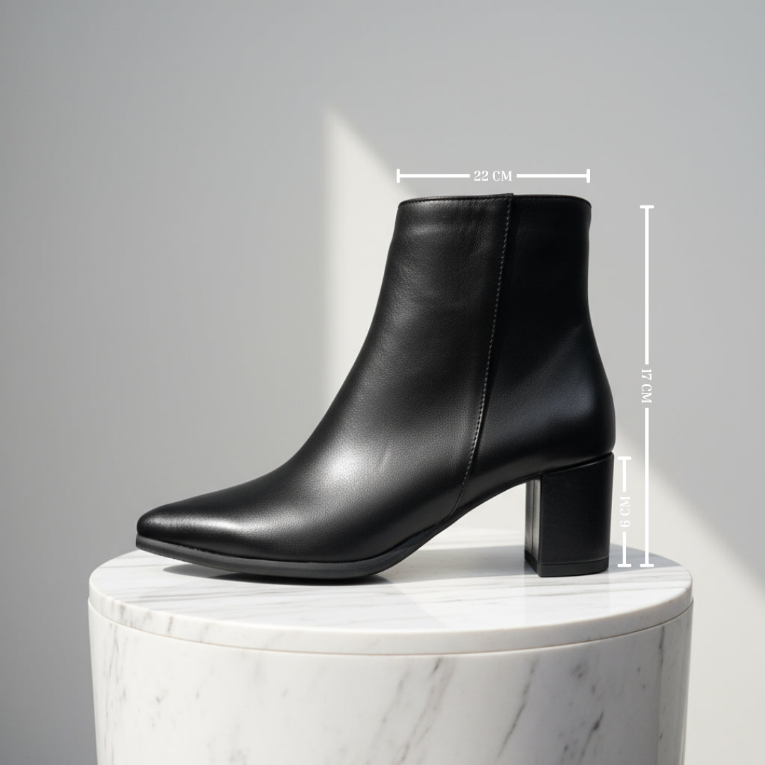 Black ankle boot on a marble pedestal with measurements indicated