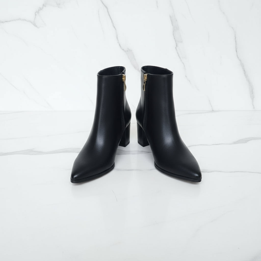 Pair of black leather ankle boots on a white background