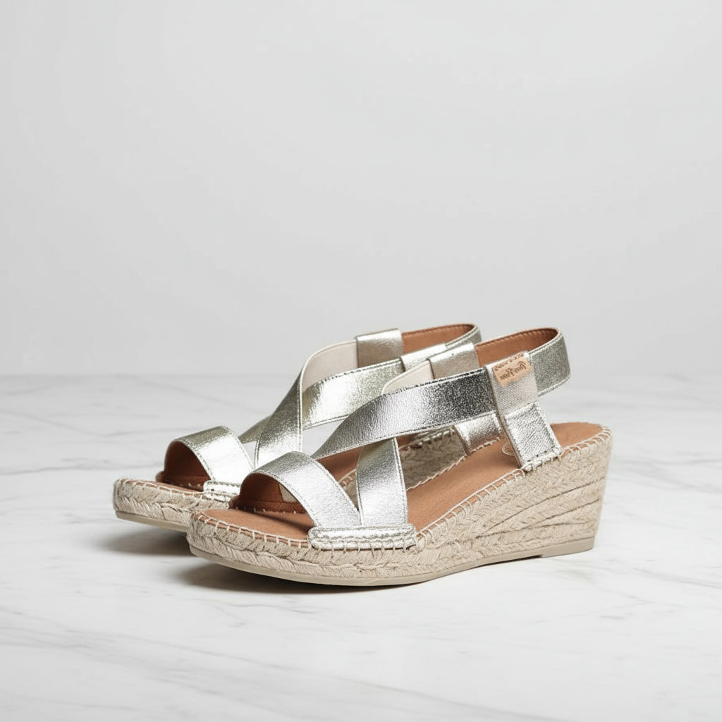Silver wedge sandals on a light gray background