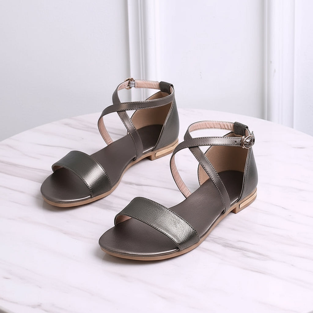 Pair of metallic green sandals on a white surface with a light gray background
