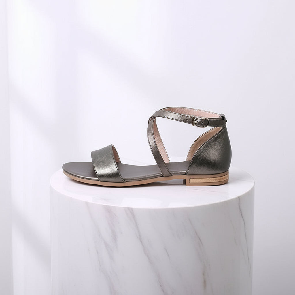 Silver sandal on a white marble pedestal with a light gray background