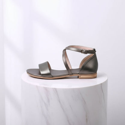 Silver sandal on a white marble pedestal with a light gray background