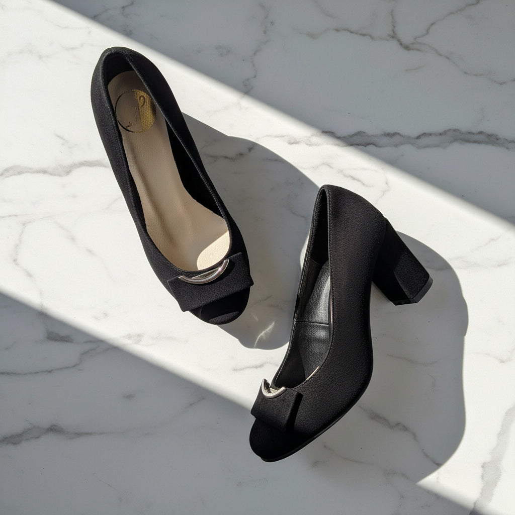 Black high-heeled shoes on a marble surface