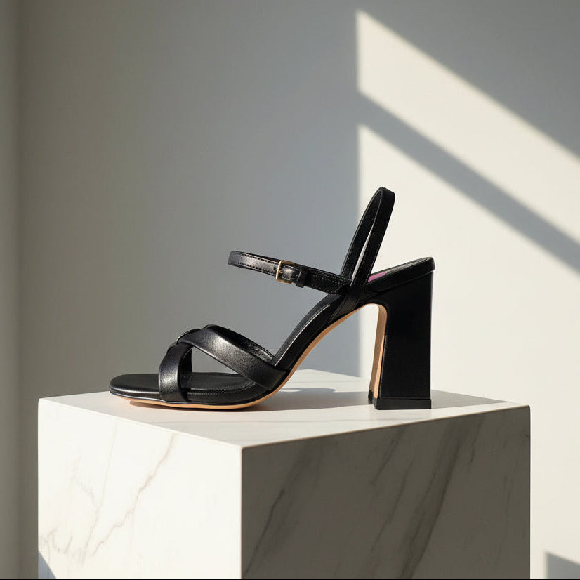 Black leather strappy sandals with gold buckle set on a block heel.