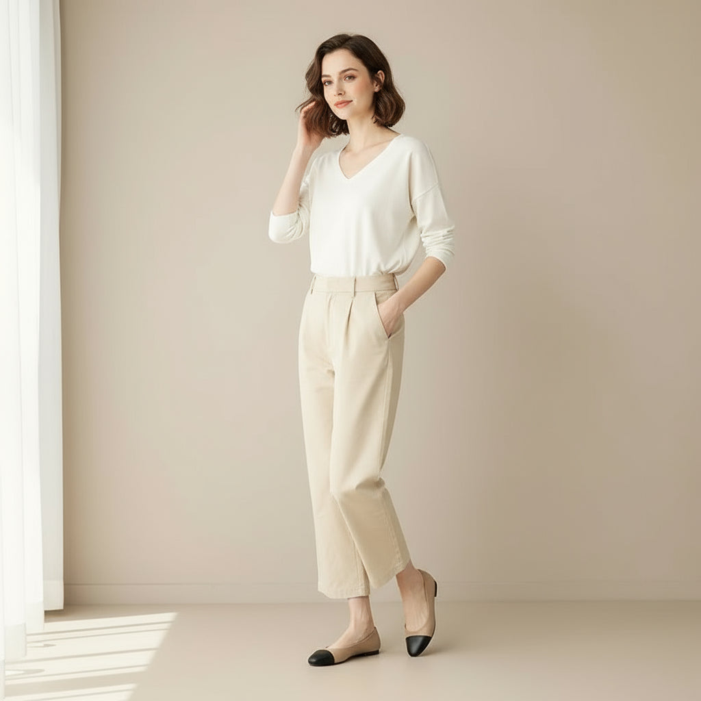 Petite feet wearing beige and black leather ballerina flats with low heel and rounded toe