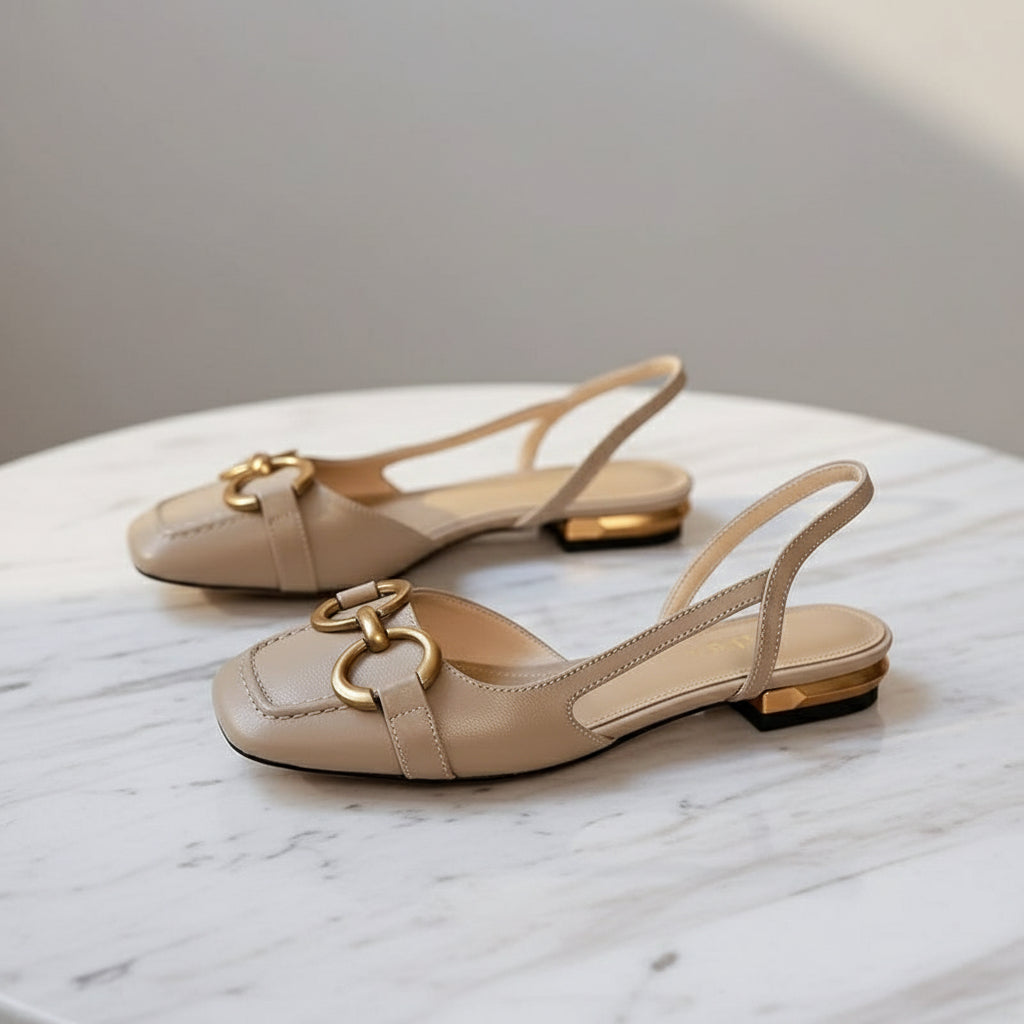 Side view of beige leather slingbacks featuring 2cm heel, elastic strap, and gold brooch detail