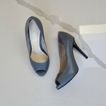 Pair of gray high-heeled shoes on a light gray background