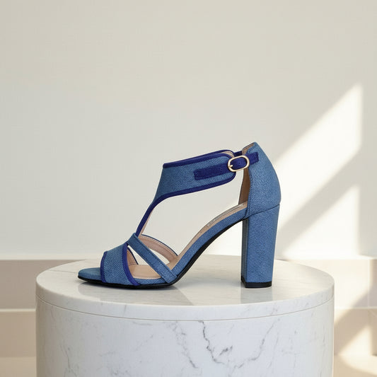 Blue sandal on a white marble pedestal with a light gray background