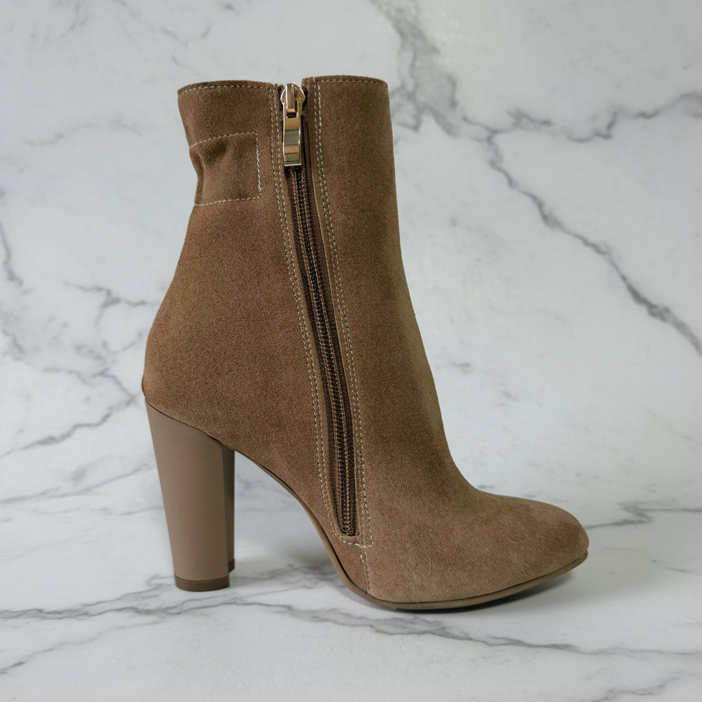 Brown suede ankle boot with a zipper on a white background
