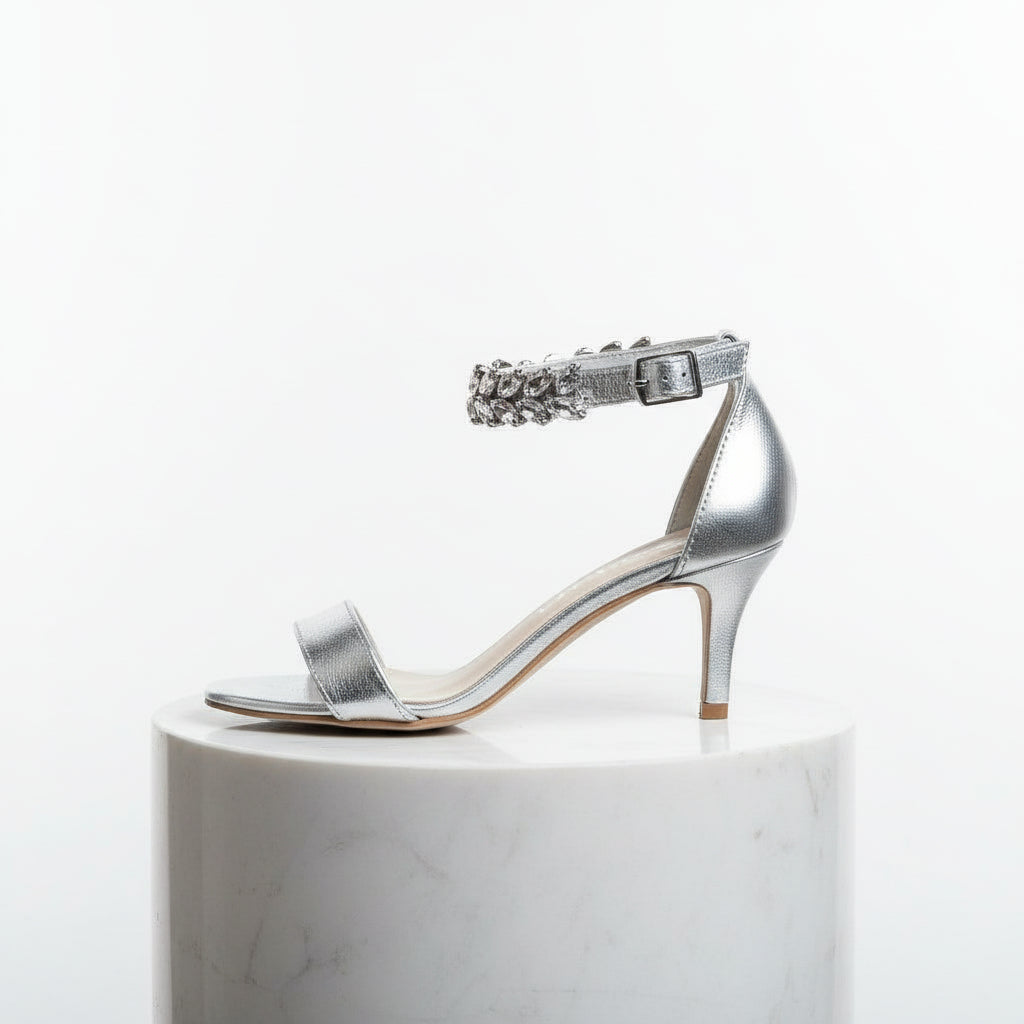 Silver high-heeled sandal with a decorative strap on a white background