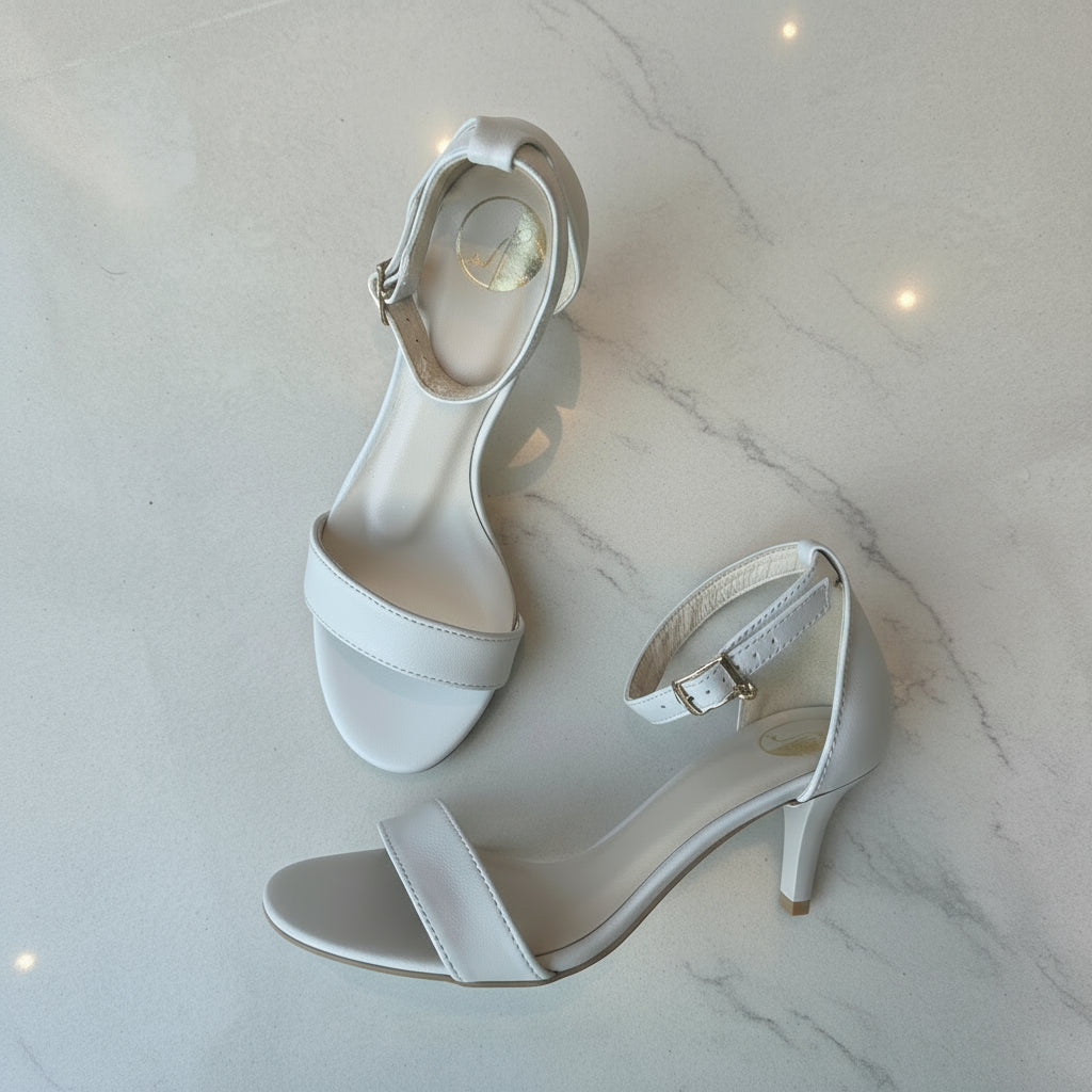 Nude leather high-heeled sandals on a light grey background.