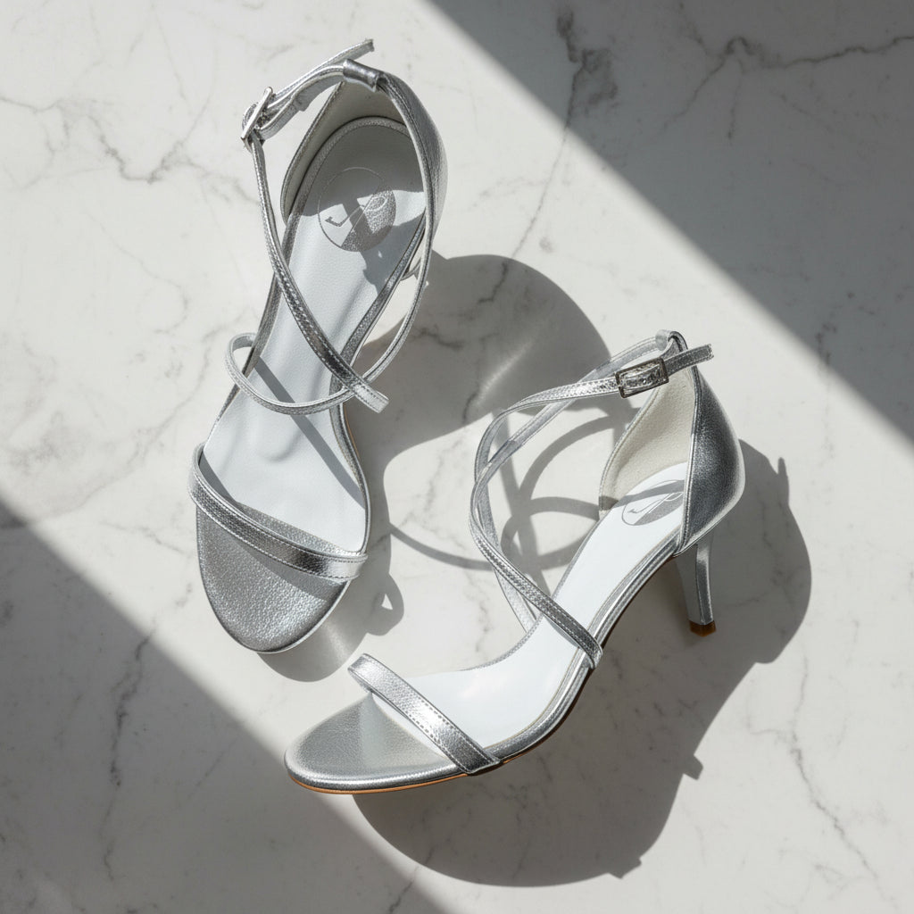 Silver high-heeled sandals on a marble surface