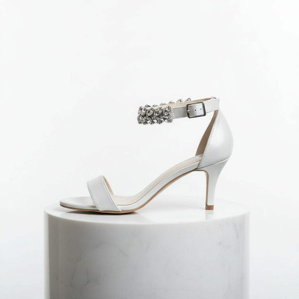 White high-heeled sandal with a decorative strap on a white background