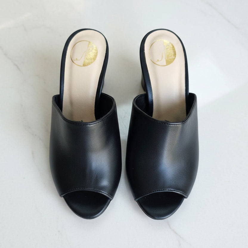 Pair of black open-toe shoes on a light gray background