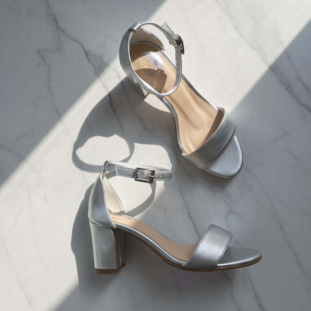 Silver high-heeled sandals on a light gray background