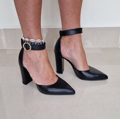 A woman wearing petite court heels in black leather
