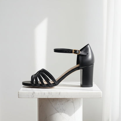 Black sandal with a block heel on a marble background