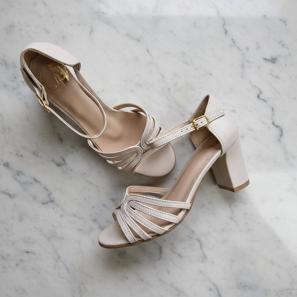 Beige high-heeled sandals on a marble surface