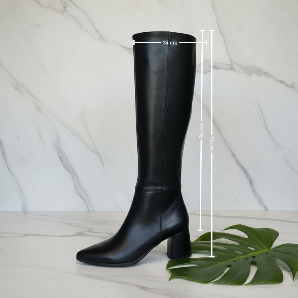 Black knee-high boot with measurements on a marble background