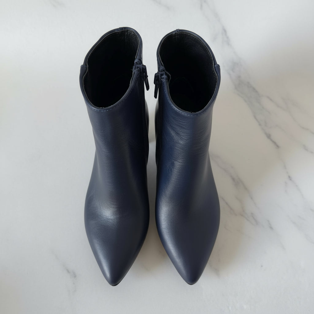 Close-up of unique studded 6cm block heel on REGINA navy leather boots.